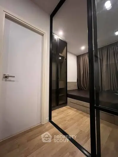 Modern bedroom with sleek glass sliding doors and wooden flooring