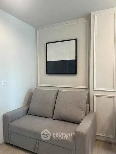 Modern living room with stylish gray sofa and minimalist wall art
