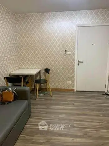 Cozy living room with modern wallpaper and sleek flooring, featuring a compact dining area and stylish seating.