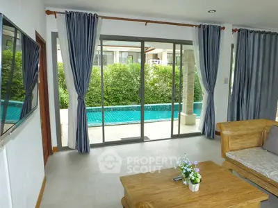 Spacious living room with pool view and elegant wooden furniture