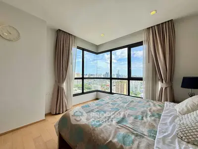 Spacious bedroom with stunning city view and large windows in modern apartment.
