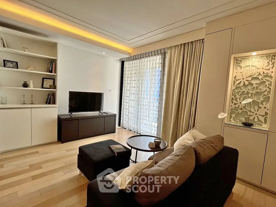 Elegant living room with modern decor and natural light, featuring a cozy sofa and stylish shelving.