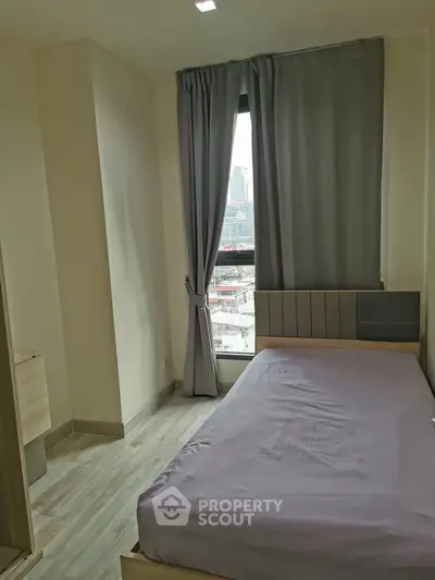 Cozy bedroom with city view, featuring modern design and natural light, perfect for urban living.