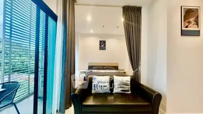 Modern studio apartment with cozy living area and balcony view, perfect for urban living.
