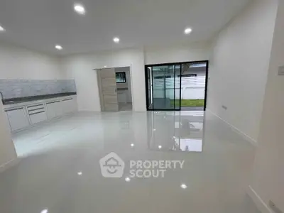 Spacious modern living room with open layout and sliding glass doors to garden.