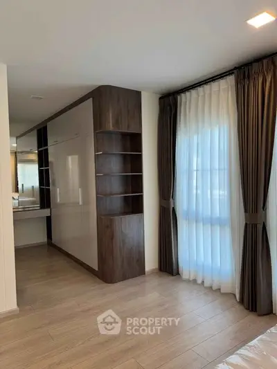 Spacious bedroom with elegant curtains and built-in storage