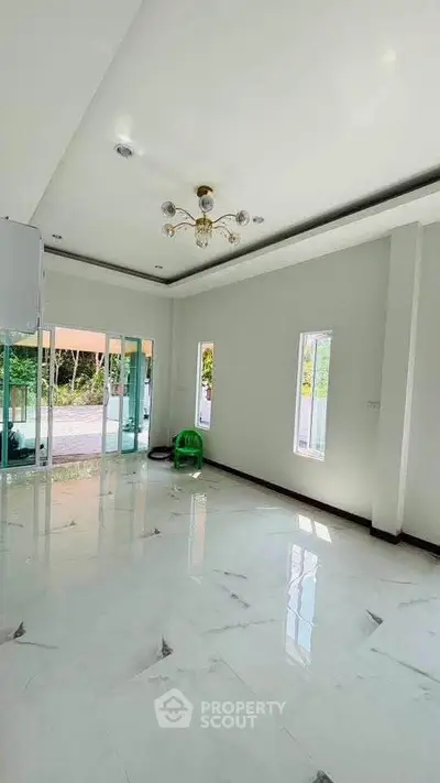 Spacious modern living room with elegant chandelier and marble flooring