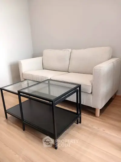 Cozy living room with a modern beige sofa and sleek glass coffee table.