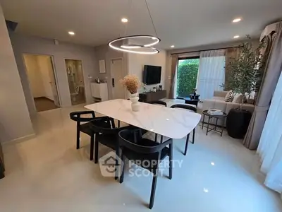 Modern dining area with sleek table, stylish chairs, and natural light.