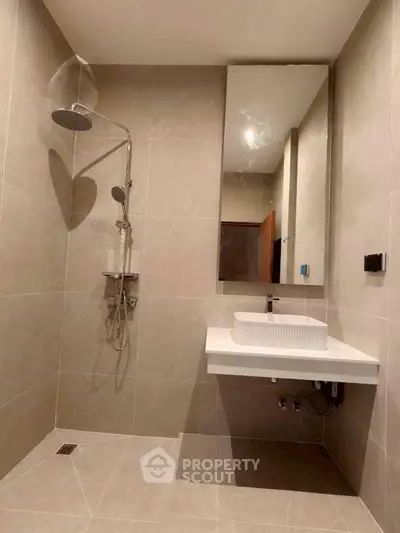 Modern bathroom with sleek shower and elegant sink in a contemporary design.