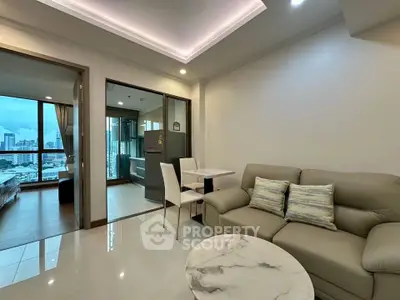 Modern living room with city view, elegant sofa, and marble coffee table in a high-rise apartment.