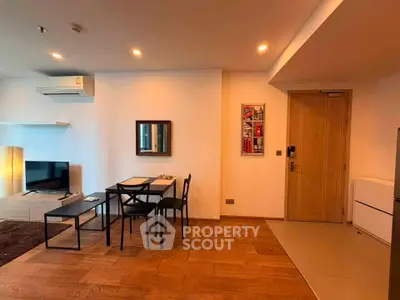 Modern living room with dining area, wooden flooring, and stylish decor in a cozy apartment.