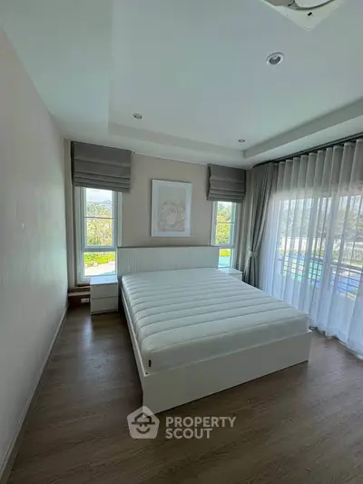 Spacious bedroom with large windows and elegant decor