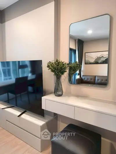 Modern living room with sleek TV, stylish mirror, and elegant decor