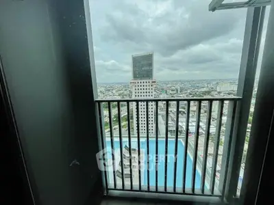Stunning high-rise balcony view overlooking cityscape and pool, perfect for urban living.