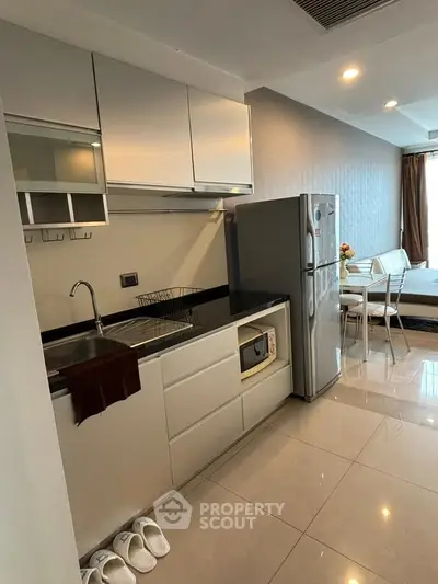 Modern kitchen with sleek cabinetry and stainless steel appliances in a stylish apartment.