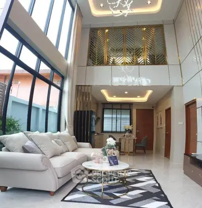 Luxurious double-height living room with elegant decor and large windows for natural light.