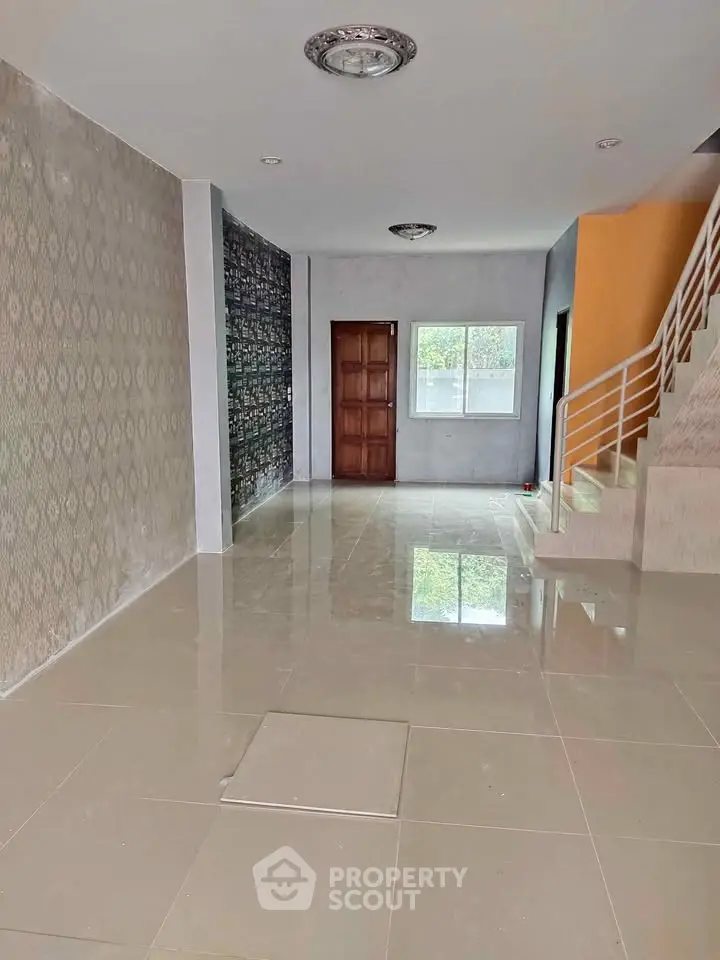 Spacious interior with modern staircase and glossy tiled flooring, perfect for customization.
