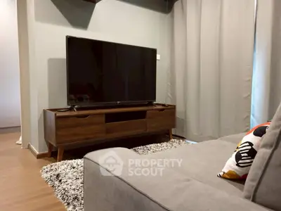 Modern living room with sleek TV stand and cozy sofa in stylish apartment.
