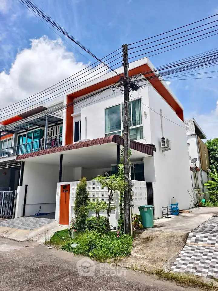 Modern corner townhouse with unique design and spacious driveway in a serene neighborhood.