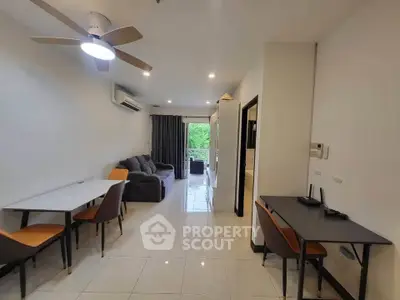 Modern living room with sleek furniture and balcony view, perfect for urban living.