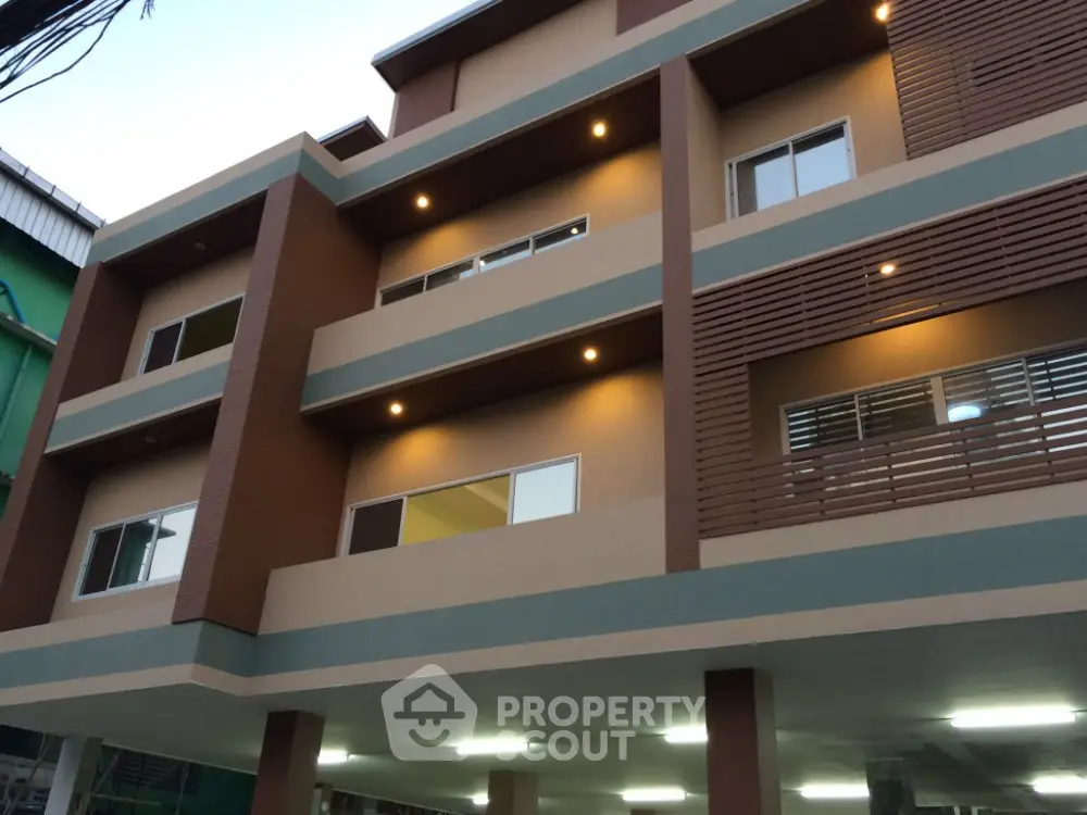 Modern multi-story building exterior with stylish design and ambient lighting