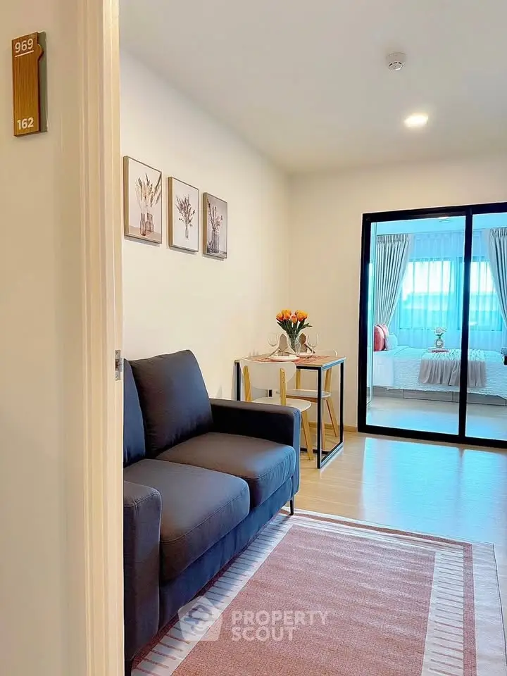 Modern living room with cozy sofa and stylish decor leading to a bright bedroom.