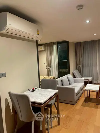 Modern living room with cozy seating and dining area, featuring elegant decor and natural lighting.