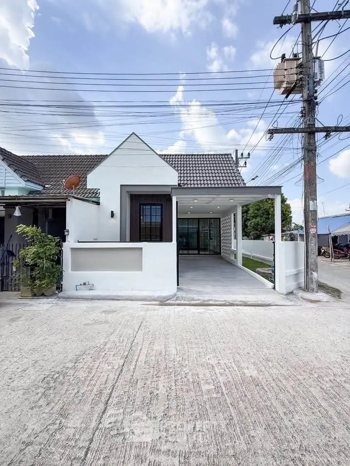 Charming single-story house with modern facade and spacious driveway in a serene neighborhood.