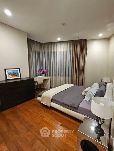 Elegant bedroom with modern decor, wooden flooring, and ambient lighting for a cozy atmosphere.