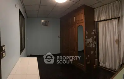 Spacious room with large wardrobe and window, ideal for customization.