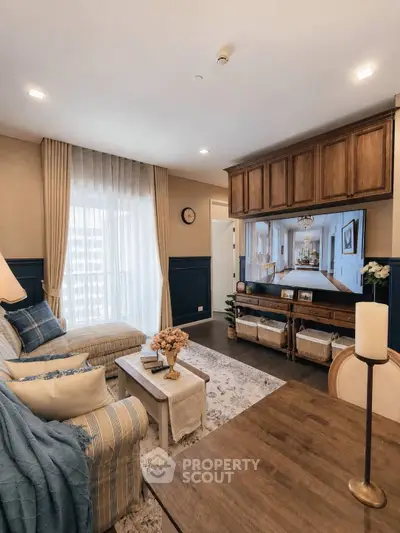 Charming living room with elegant decor, large window, and cozy seating area in a stylish apartment.