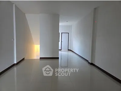 Spacious empty hallway with glossy tiled flooring and white walls