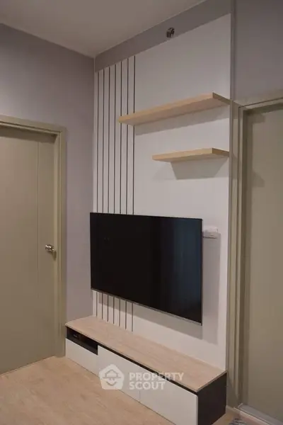 Modern living room with wall-mounted TV and minimalist shelves