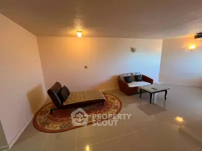 Spacious living room with modern chaise lounge and cozy sofa, ideal for relaxation and entertaining.