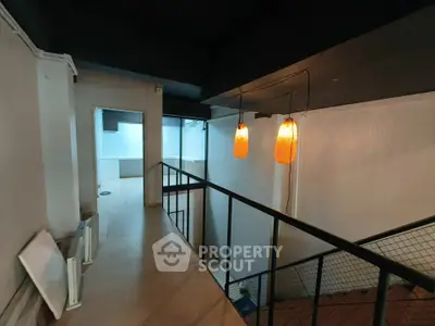 Modern industrial loft with stylish lighting and open mezzanine design, perfect for creative living or workspace.