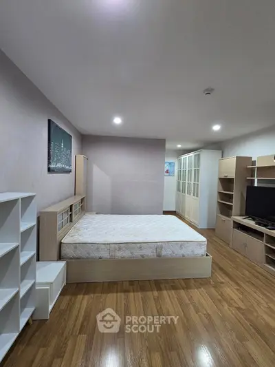 Spacious bedroom with modern furniture and wooden flooring