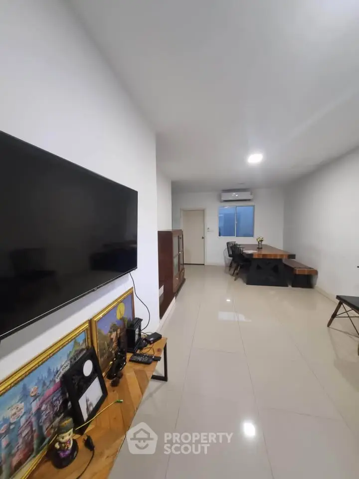 Modern living room with sleek TV setup and stylish dining area