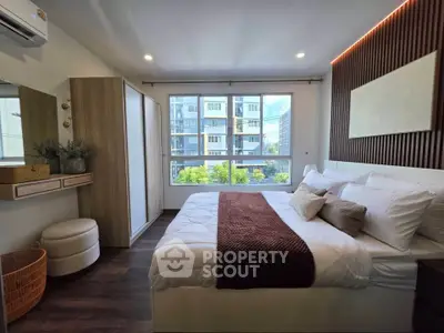 Modern bedroom with large window and stylish decor in urban apartment