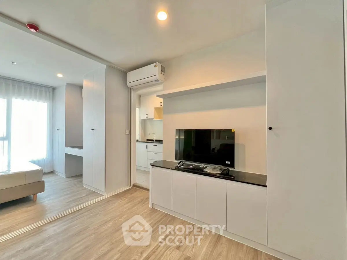 Modern living room with sleek design and open layout, featuring built-in storage and natural light.