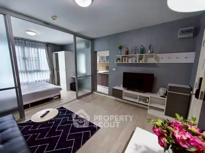 Modern open-plan living room with stylish decor and adjacent bedroom in a contemporary apartment.