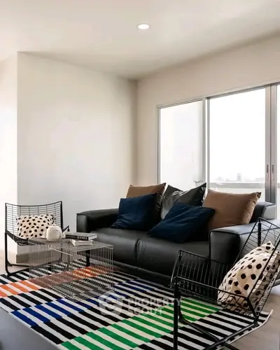 Modern living room with stylish furniture and large windows offering natural light.