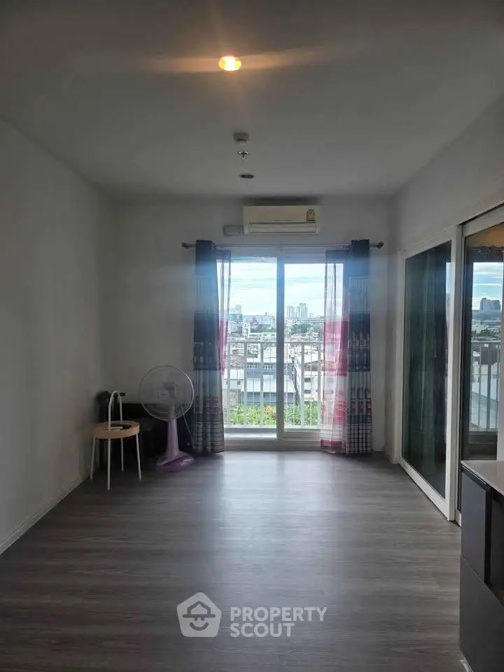Spacious living room with city view and large windows in modern apartment.