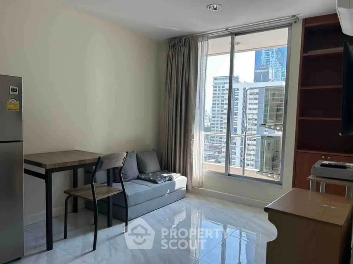 Modern living room with city view, featuring sleek furniture and large windows for natural light.