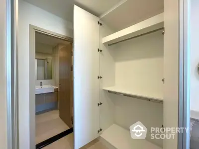 Spacious walk-in closet with modern bathroom view in luxury apartment