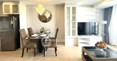 Modern living room with dining area, elegant chandelier, and sleek TV setup in a stylish apartment.
