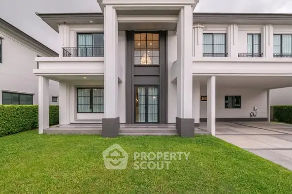 Elegant modern house exterior with lush green lawn and spacious driveway