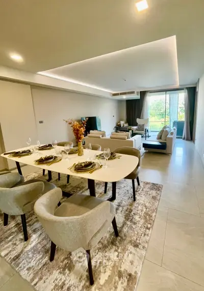 Spacious modern living room with elegant dining area and large windows offering natural light.