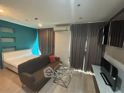 Modern studio apartment with stylish decor and cozy furnishings, featuring a comfortable bed and sleek sofa.