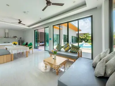 Spacious modern living room with pool view and open layout, perfect for relaxation and entertaining.